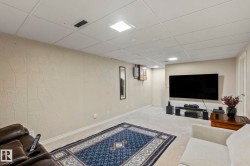 Recessed lighting, drop ceiling, textured wall finish, and wall-mounted television - 