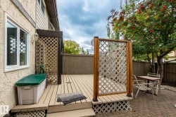 Expansive wooden deck with lattice accents and a brick-paved patio - 