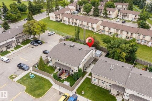 Townhome featuring a private fenced yard, a rear patio area, and an asphalt shingle roof - 716 Clareview Rd Nw, Edmonton, AB 