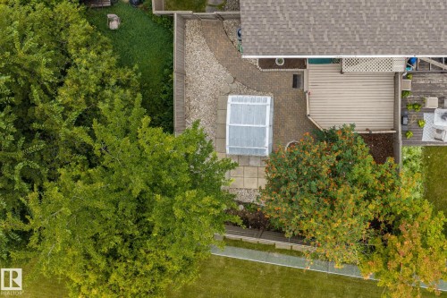 Expansive outdoor deck with slatted surface, gravel patio, paver patio, and greenhouse structure - 716 Clareview Rd Nw, Edmonton, AB 