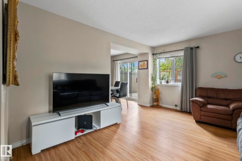 Wood-finish flooring, neutral wall paint, and a large window providing natural light - 716 Clareview Rd Nw, Edmonton, AB 