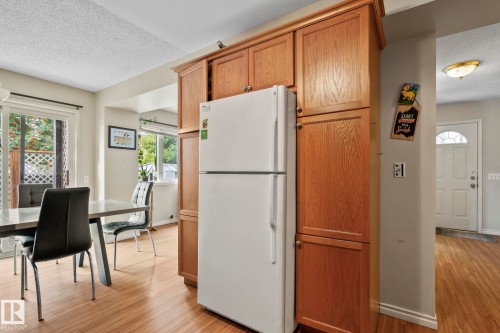 Built-in wood-finish cabinetry, wood-finish flooring, and a white sliding glass door - 716 Clareview Rd Nw, Edmonton, AB 