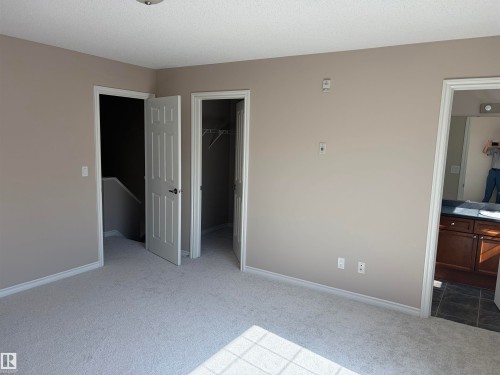 Light-toned wall paint, white trim, and light-colored carpeting - #100 13825 155 Av Nw, Edmonton, AB 