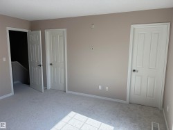 Neutral wall paint, white trim, light-colored carpeting, and three paneled doors - 