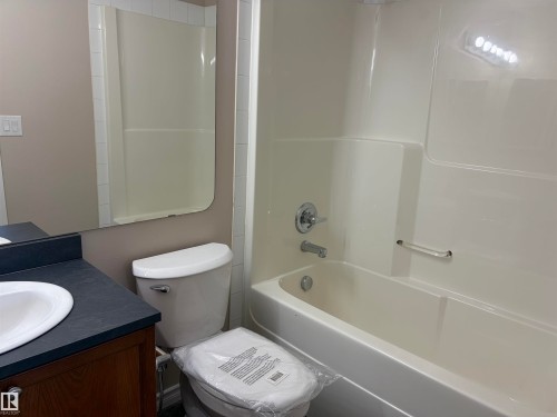 Tub and shower combination with chrome fixtures and grab bar - #100 13825 155 Av Nw, Edmonton, AB 
