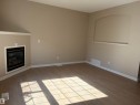 Corner fireplace with black insert, wood-finish flooring, and a decorative wall niche with an arched top - #100 13825 155 Av Nw, Edmonton, AB 