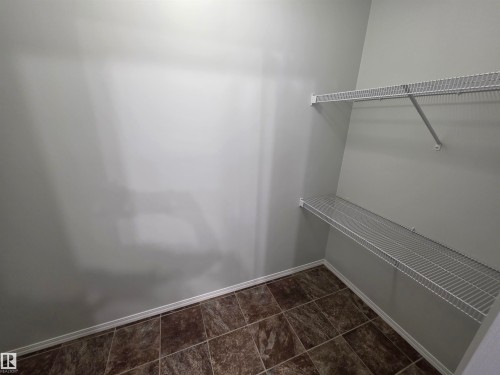 Built-in wire shelving, tiled flooring, and light-toned walls - #206 12045 22 Av Sw, Edmonton, AB 
