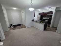 Kitchen featuring dark wood cabinetry, stainless steel appliances, and a breakfast bar with a double basin sink - 