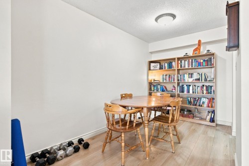 Light-toned wood-finish flooring, two built-in shelving units, and flush mount lighting - #1507 9835 113 St Nw, Edmonton, AB 