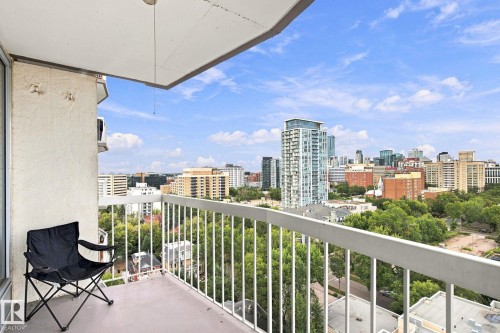 Balcony with a concrete floor, white metal railing, and a cityscape backdrop - #1507 9835 113 St Nw, Edmonton, AB 