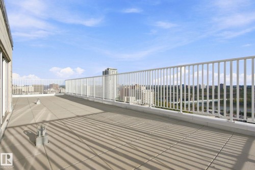 Expansive rooftop deck featuring a tiled surface and white perimeter railing - #1507 9835 113 St Nw, Edmonton, AB 