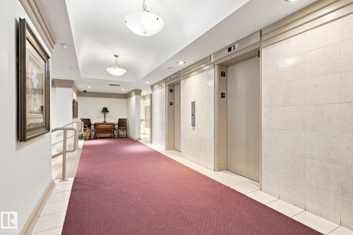 Elevator lobby featuring two elevators, wall sconces, ceiling-mounted light fixtures, and tiled walls - #1507 9835 113 St Nw, Edmonton, AB 