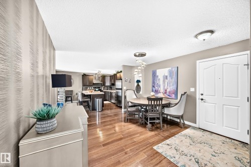 Hardwood-finish flooring, a contemporary chandelier, recessed lighting, and a paneled entry door - #418 279 Suder Greens Dr Nw, Edmonton, AB 