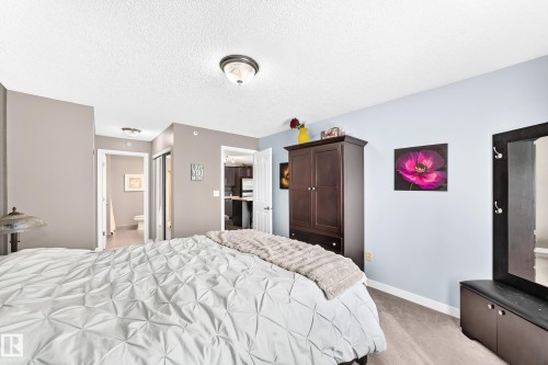 Carpeted flooring, neutral wall colors, flush mount lighting, and white trim - #418 279 Suder Greens Dr Nw, Edmonton, AB 