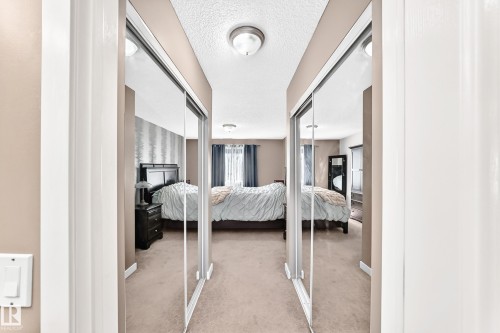 Mirrored sliding closet doors and neutral wall paint - #418 279 Suder Greens Dr Nw, Edmonton, AB 