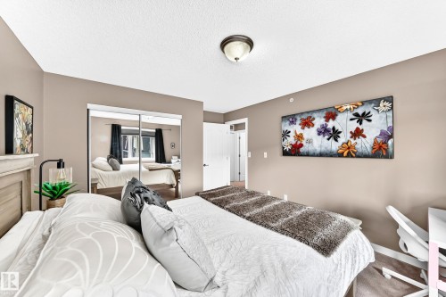 Recessed ceiling light fixture, neutral wall paint, and mirrored sliding closet doors - #418 279 Suder Greens Dr Nw, Edmonton, AB 