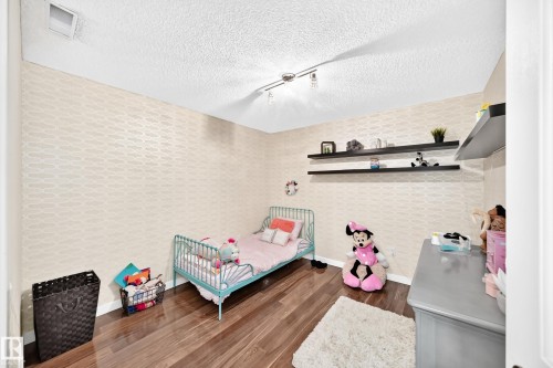 Patterned wall covering, hardwood-finish flooring, built-in floating shelves, track lighting fixture - #418 279 Suder Greens Dr Nw, Edmonton, AB 