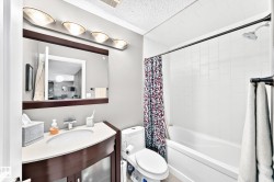 Vanity with integrated sink, white countertop, and dark wood-finish cabinetry - 