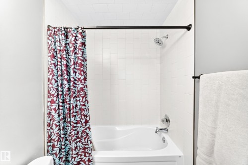 White tiled shower surround with a built-in tub - #418 279 Suder Greens Dr Nw, Edmonton, AB 
