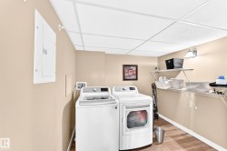 Utility area with wood-finish flooring, wire shelving, and a drop ceiling - 