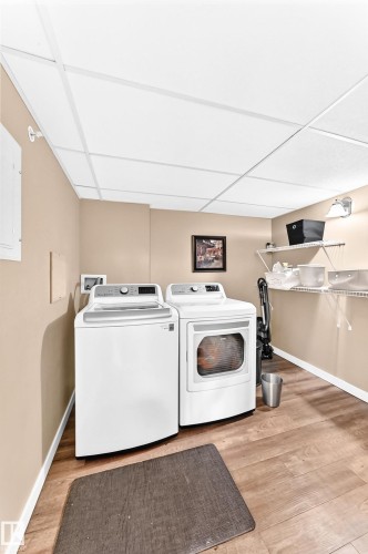 Wood-finish flooring, drop ceiling, and wall-mounted shelving units - #418 279 Suder Greens Dr Nw, Edmonton, AB 