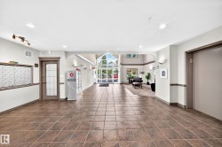 Spacious common area featuring tile flooring, a mail center, and an elevator - 