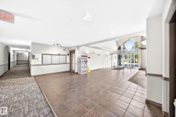 Tiled flooring entry, glass-paneled double doors, vaulted glass ceiling, built-in mailboxes, and recessed lighting - 