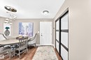 Hardwood-finish flooring, contemporary chandelier, paneled entry door, and sliding closet doors with frosted glass panels - #418 279 Suder Greens Dr Nw, Edmonton, AB 