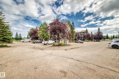 Multi-story building featuring multiple balconies and surrounding mature trees - #418 279 Suder Greens Dr Nw, Edmonton, AB 