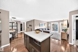 Kitchen island with integrated microwave, wood-finish flooring, recessed lighting, and a sliding glass door - 