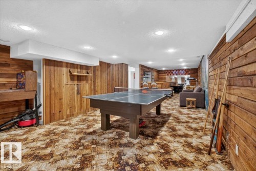 Recreational room featuring wood-paneled walls, a drop ceiling with recessed lighting, and patterned carpet flooring - 4027 74 Street Nw, Edmonton, AB - Indoor Photo Showing Other Room