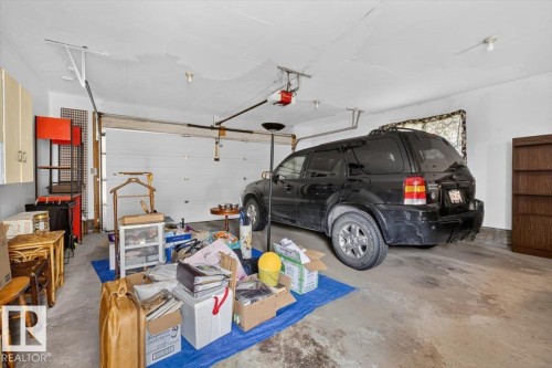 Garage featuring an overhead door and concrete flooring - 4027 74 Street Nw, Edmonton, AB - Indoor Photo Showing Garage