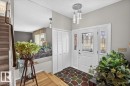 Entryway featuring a decorative glass front door with coordinating sidelights, a contemporary multi-bulb ceiling fixture, a mosaic-patterned floor, and bi-fold closet doors - 4027 74 Street Nw, Edmonton, AB  - Indoor Photo Showing Other Room 