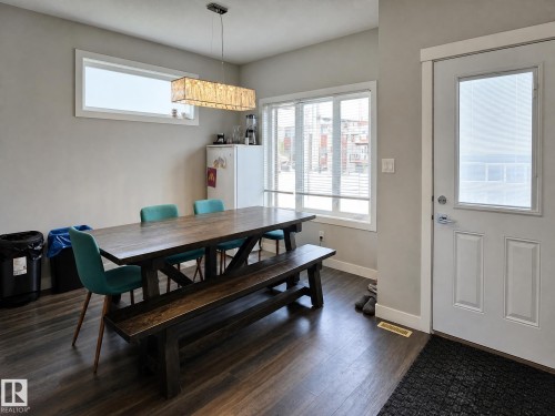 Wood-finish flooring throughout, complemented by a white panel door with integrated window - 13309 128 Street Nw, Edmonton, AB 