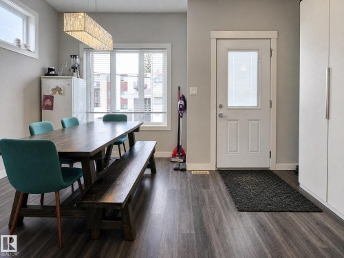 Wood-finish flooring throughout, white framed window with blinds, and white entry door with privacy glass - 13309 128 Street Nw, Edmonton, AB 