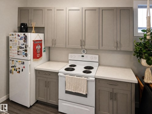 White refrigerator, electric range, and gray cabinetry with silver-tone hardware - 13309 128 Street Nw, Edmonton, AB 