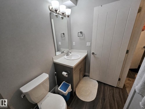 Contemporary vanity with an undermount sink, light-toned countertop, and brushed nickel hardware - 13309 128 Street Nw, Edmonton, AB 