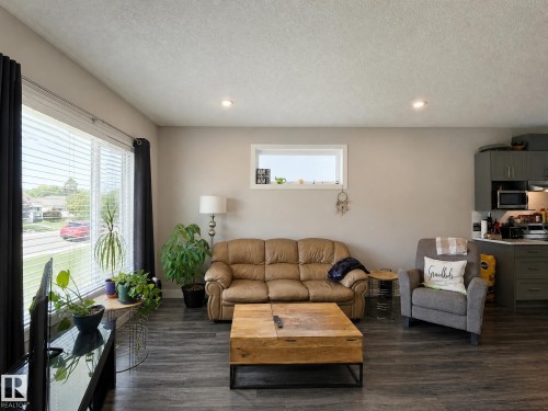 Recessed lighting, wood-finish flooring, large front-facing window with blinds, kitchen with upper and lower cabinetry, built-in microwave - 13309 128 Street Nw, Edmonton, AB 