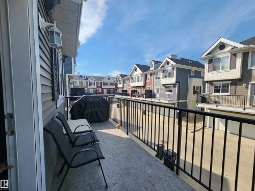 Balcony with black metal railings and a textured concrete surface - #75 8315 180 Av Nw, Edmonton, AB 