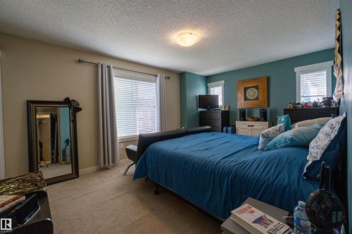 Wall-to-wall carpeting and multiple windows with blinds, complemented by a ceiling-mounted light fixture - #75 8315 180 Av Nw, Edmonton, AB 