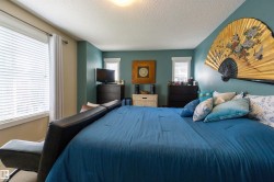 Recessed ceiling lighting complements the perimeter windows, featuring horizontal blinds and curtain rods - 