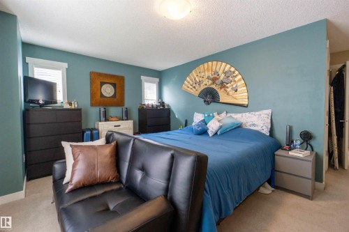 Recessed windows with blinds, light blue wall paint, light-toned carpet flooring, and a flush mount ceiling light fixture - #75 8315 180 Av Nw, Edmonton, AB 