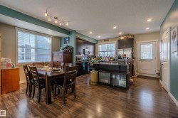 Open-concept living space featuring wood-finish flooring, recessed lighting, and a track light fixture - 