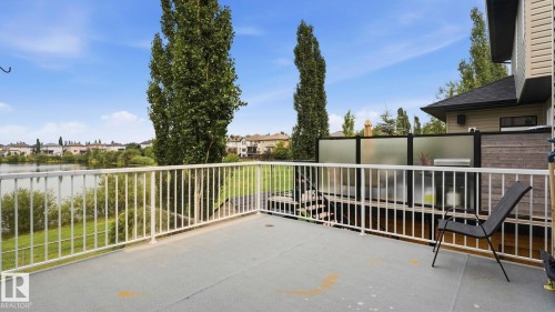 Exterior deck with white railing overlooking a body of water - 6116 53 Avenue, Beaumont, AB - Outdoor With Exterior