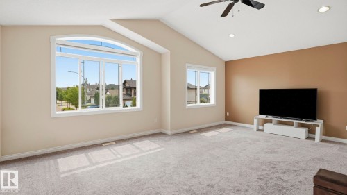Vaulted ceiling room featuring light gray carpeting, two windows, and recessed lighting - 6116 53 Avenue, Beaumont, AB - Indoor
