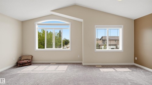 Spacious room featuring vaulted ceilings, neutral-toned walls, and grey carpeting - 6116 53 Avenue, Beaumont, AB - Indoor Photo Showing Other Room