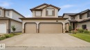 Two-story residential property featuring a two-car garage with panel doors and a concrete driveway - 6116 53 Avenue, Beaumont, AB  - Outdoor With Facade 