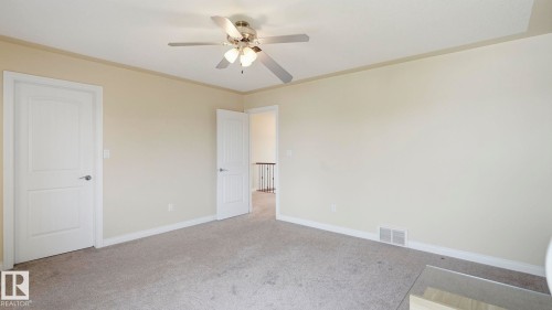 Spacious room featuring neutral carpet flooring, light-colored wall paint, white trim, and a ceiling fan with integrated lighting - 6116 53 Avenue, Beaumont, AB - Indoor Photo Showing Other Room