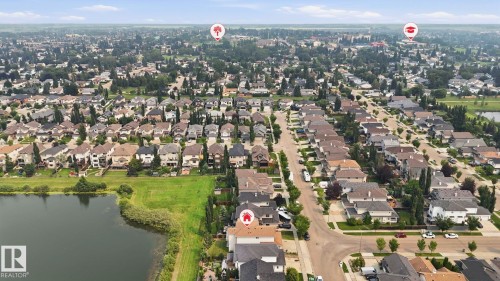 Aerial perspective showcasing a residential neighborhood with a prominent body of water and green space - 6116 53 Avenue, Beaumont, AB - Outdoor With Body Of Water With View