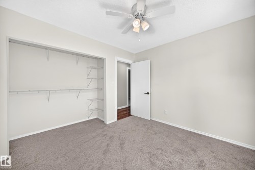 Spacious room featuring neutral carpeting, light-toned walls, and a ceiling fan with integrated lighting - 12721 117 Street Nw, Edmonton, AB 